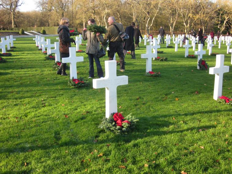 Volunteers lay holiday wreaths at the headstones. 