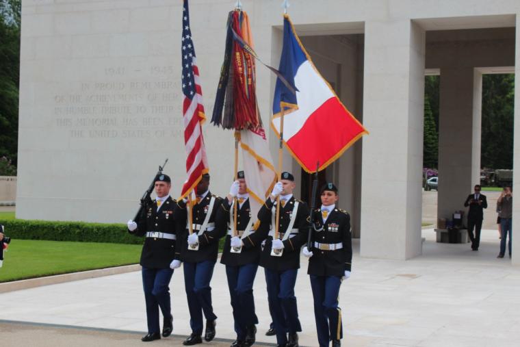 A U.S. Color Guard stands with flags and rifles outside the chapel.