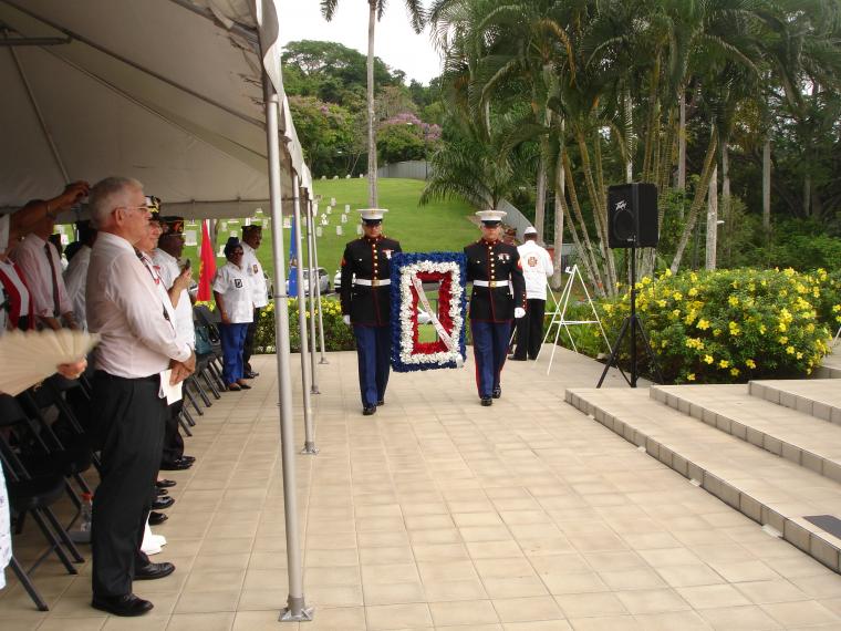 Marines carry a floral decoration during the ceremony. 
