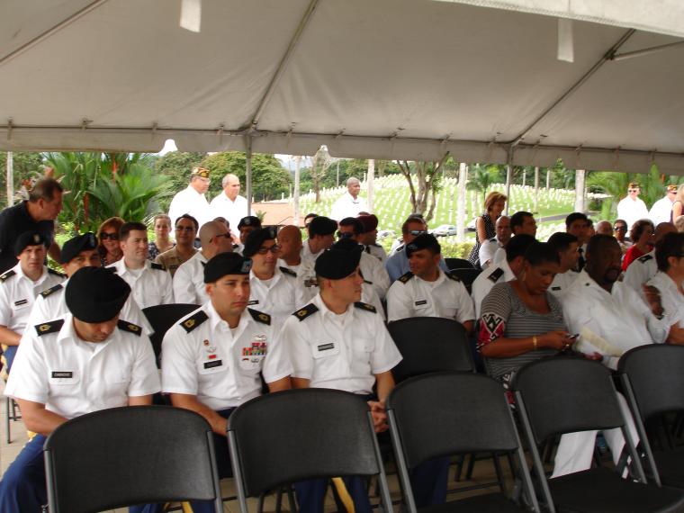 Attendees sit under a tent for the ceremony.