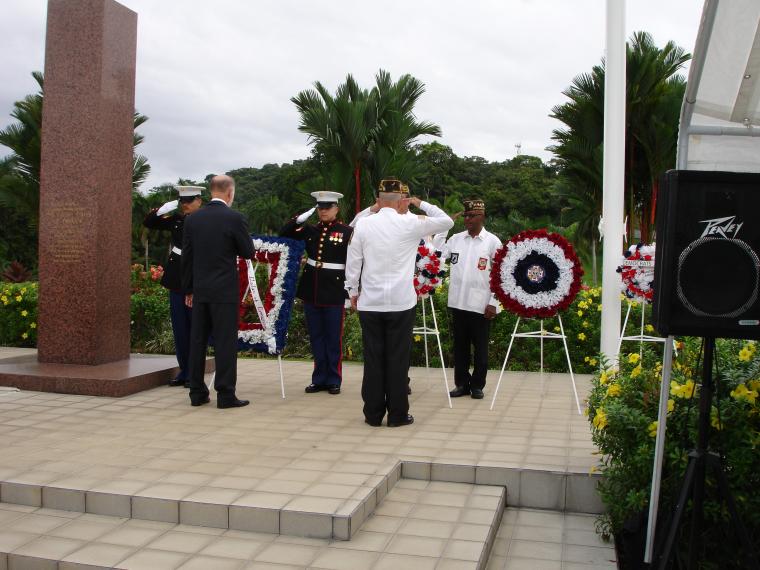 Men salute after the wreaths are laid. 