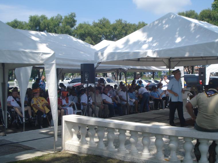 Attendees sit under tents during the ceremony. 