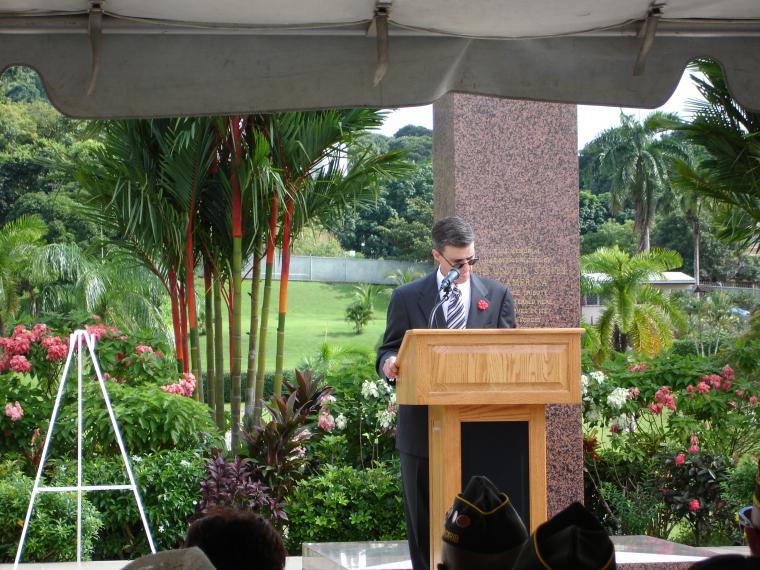 A man delivers remarks from the podium during the ceremony. 