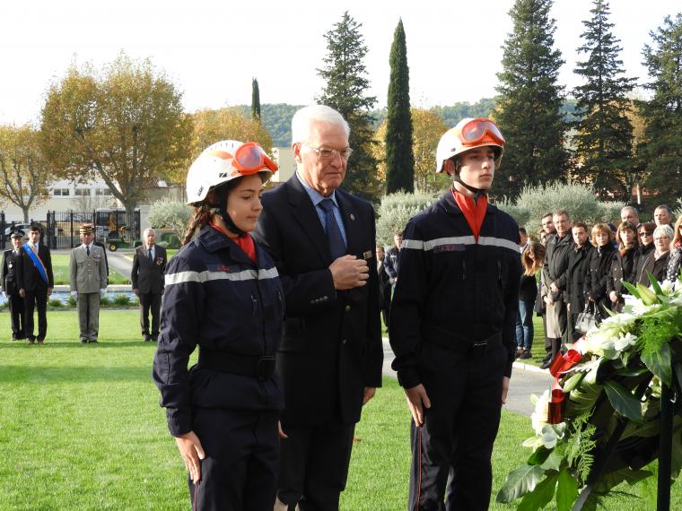 A woman and two men pause after the wreath laying. 