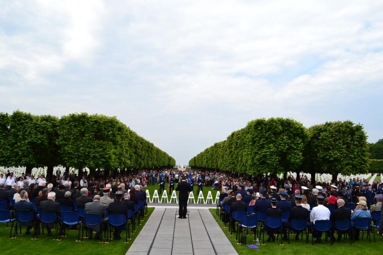 Hundreds of people sit and stand during the ceremony. 