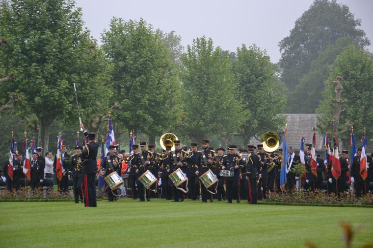 Members of French military band stand with instruments. 