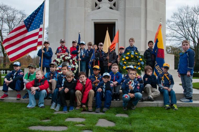 Cub Scouts sit and stand outside the chapel after the ceremony. 