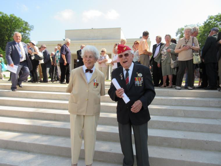 A French man and woman, both veterans of Normandy, stand in front of the chapel. 