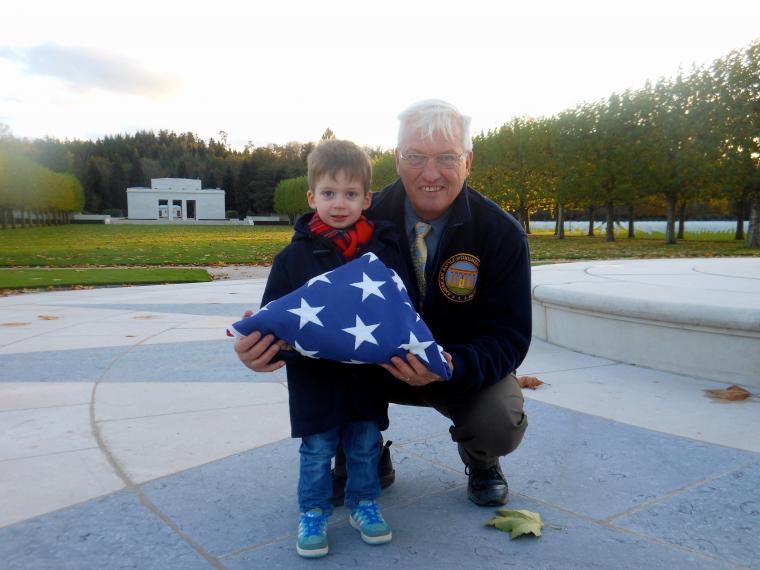 Aaron Howson and Superintendent Anderson stand with folded flag. 