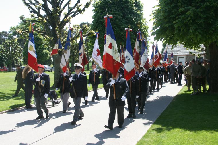 A group of flag bearers march into the cemetery for the ceremony.