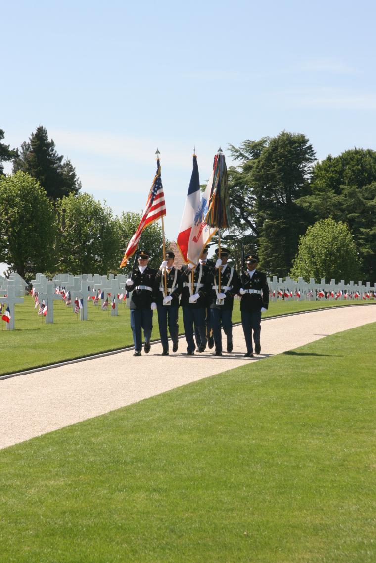 An American Color Guard marches into the cemetery for ceremony.