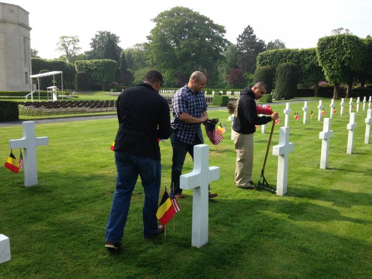 Men assist in the placement of the American and Belgian flag. 