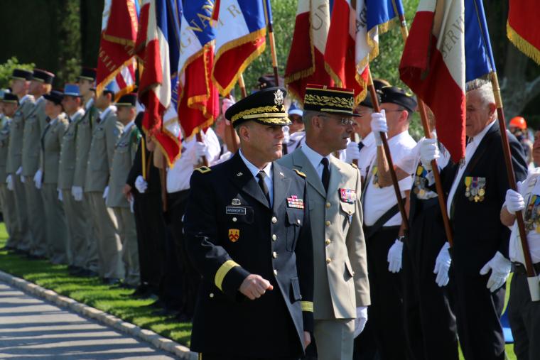 Leaders in the French and American military walk in front of the flag bearers during the ceremony.