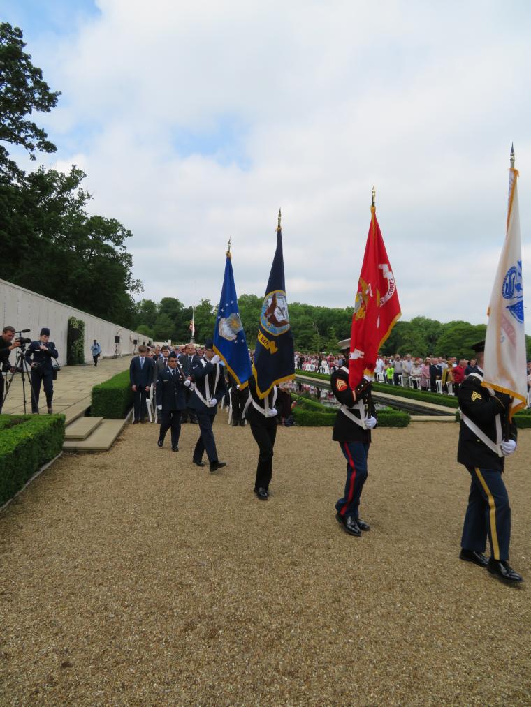 Members of the American military carry the service flags during the ceremony. 