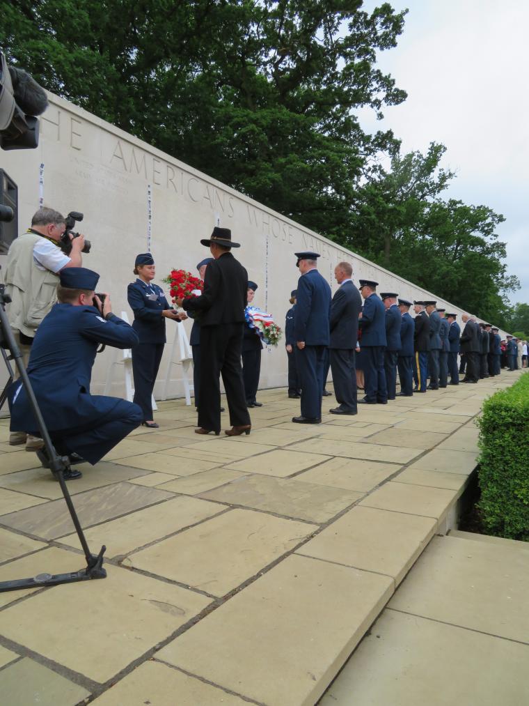 A long line of people prepare to lay wreaths at the Wall of the Missing. 