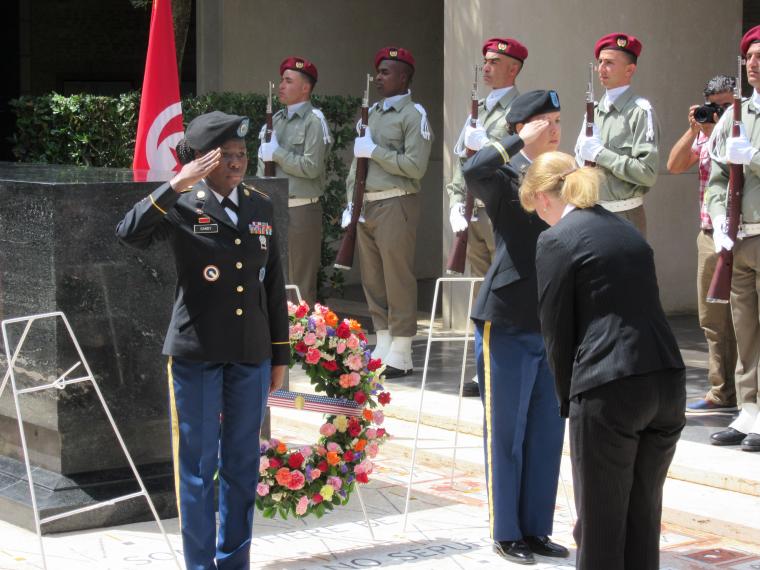 A woman lays a wreath during the ceremony. 