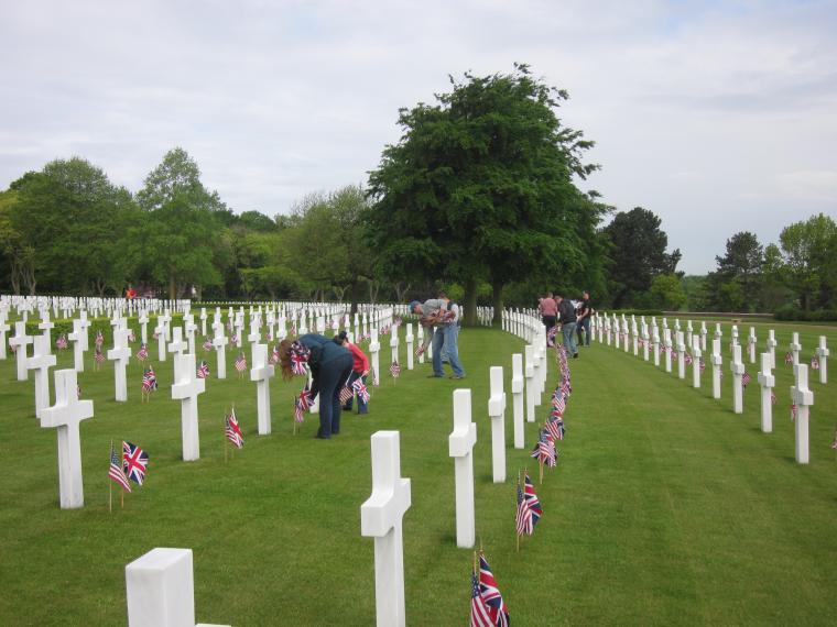 Volunteers place American and British flags in front of every headstone. 