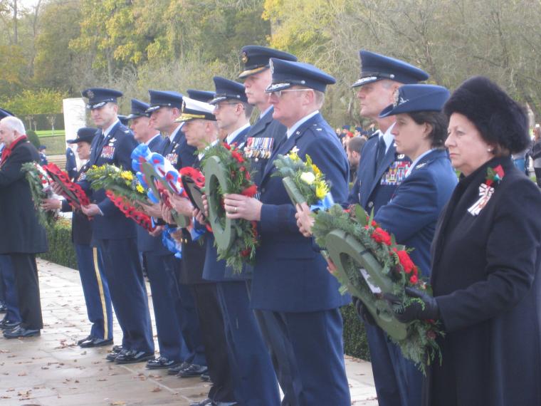 Members of the official party stand with wreaths in hand.