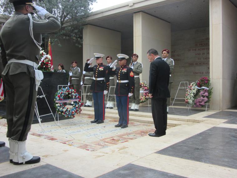 Ambassador Rubinstein bows his head after laying a wreath. 