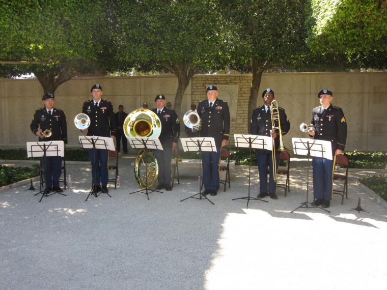 Soldiers in uniform stand with their instruments.
