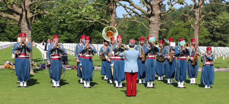 Members of the band in uniform play their instruments. 