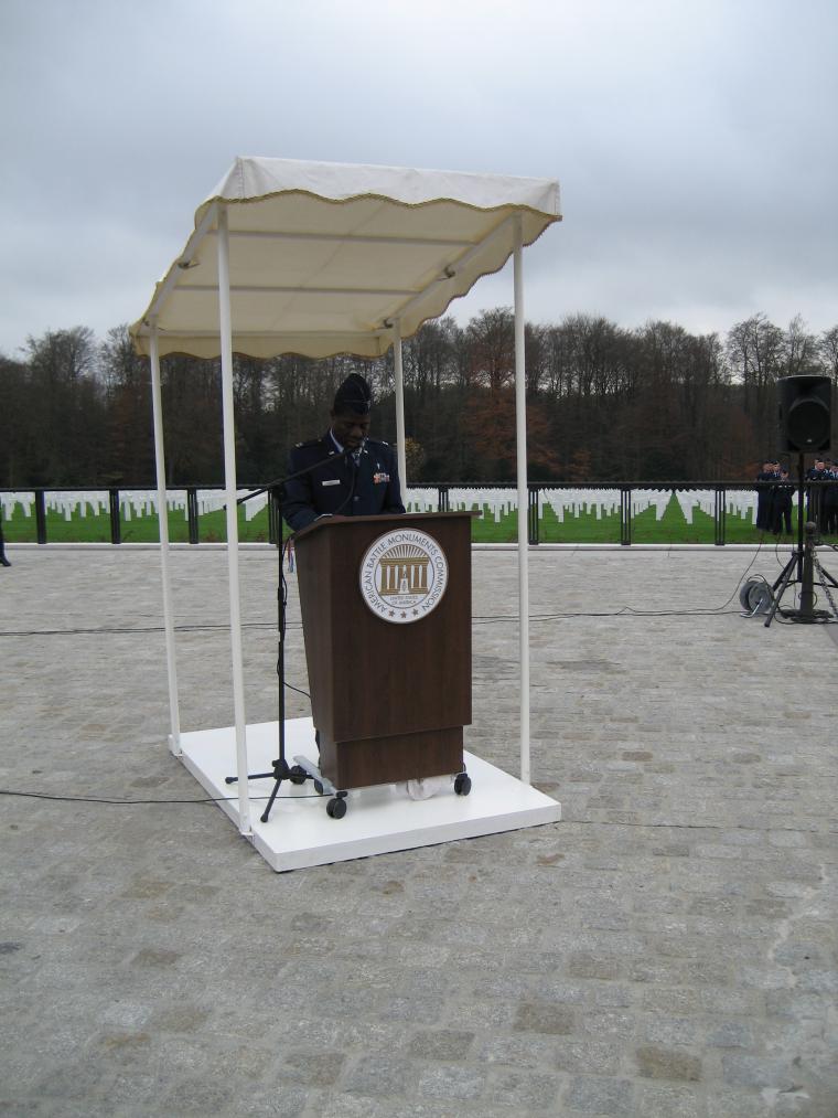 A man in uniform delivers remarks from behind a podium during the ceremony. 
