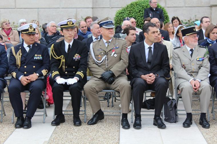 Men in uniform sit in the front row during the ceremony. 