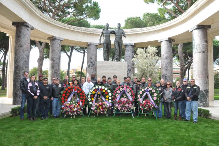 Motorcyclists stand with the floral wreaths after the ceremony. 