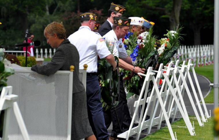 Men lay floral wreaths during the ceremony. 