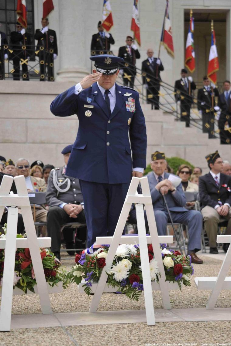 A U.S. military official salutes after laying a wreath. 