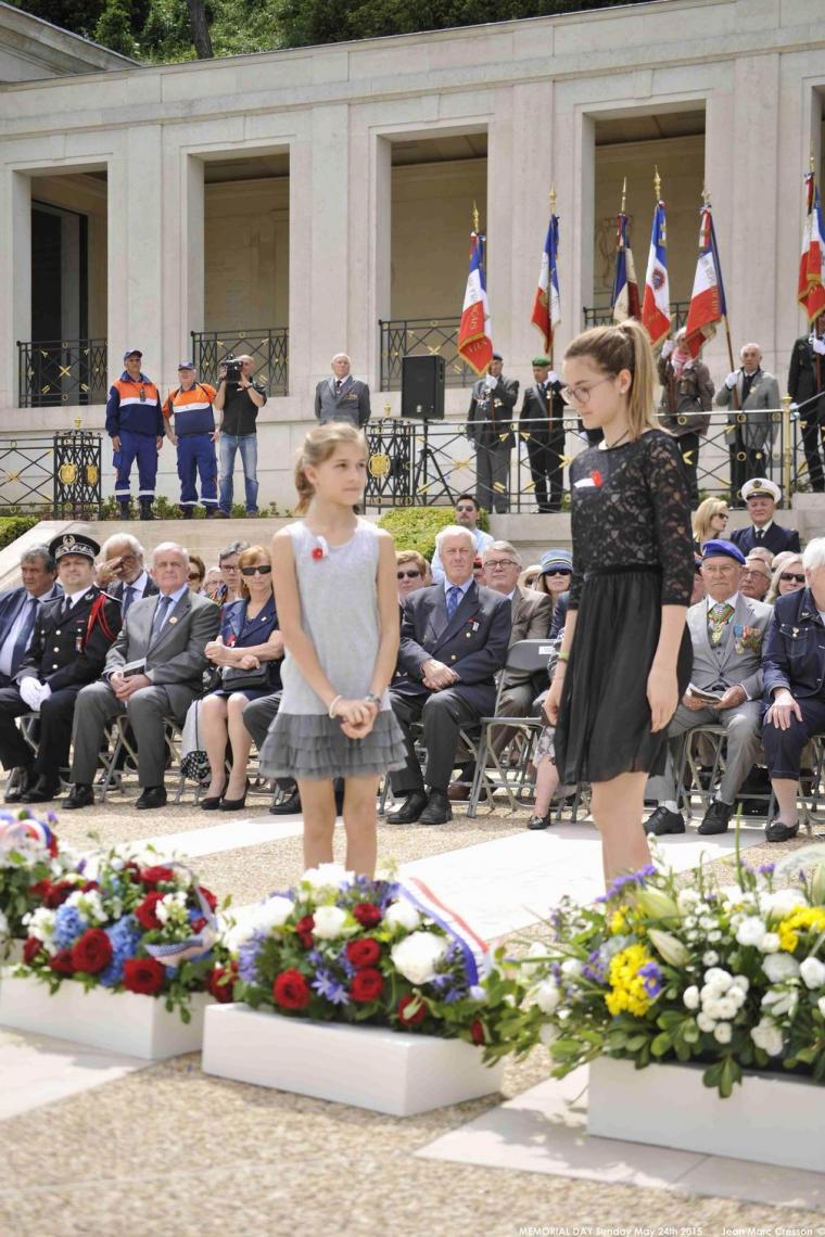 Two girls assist with the wreath laying. 