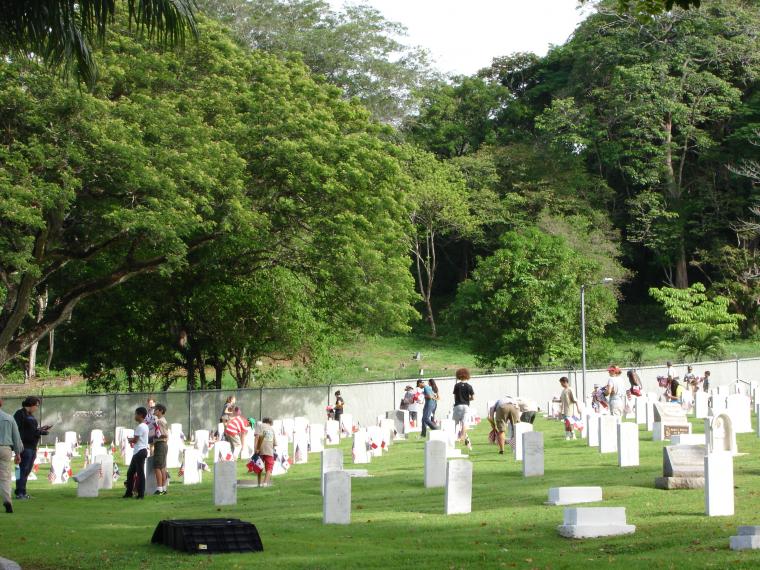 People plan an American and Panamanian flag in front of every headstone. 