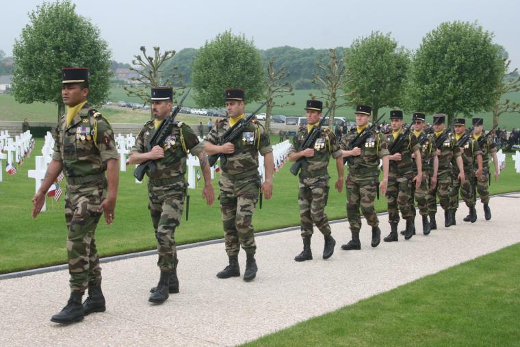 Members of the French Army march with weapons during the ceremony. 