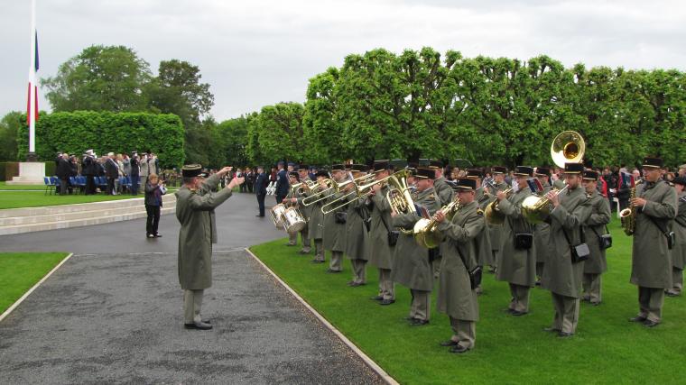 Members of the band stand in straight lines playing their instruments.
