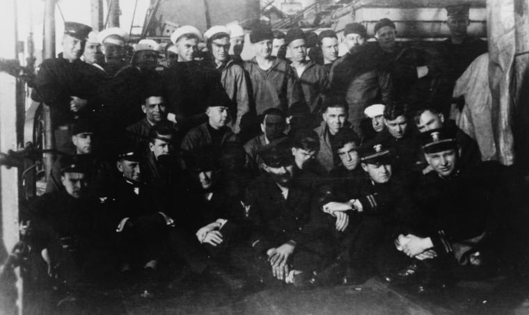 Historic photo shows men on the deck of a ship. 