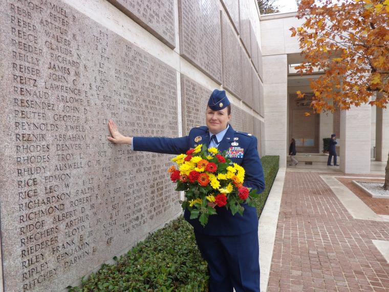 Maj. Martin stands with flowers at the Wall of the Missing. 
