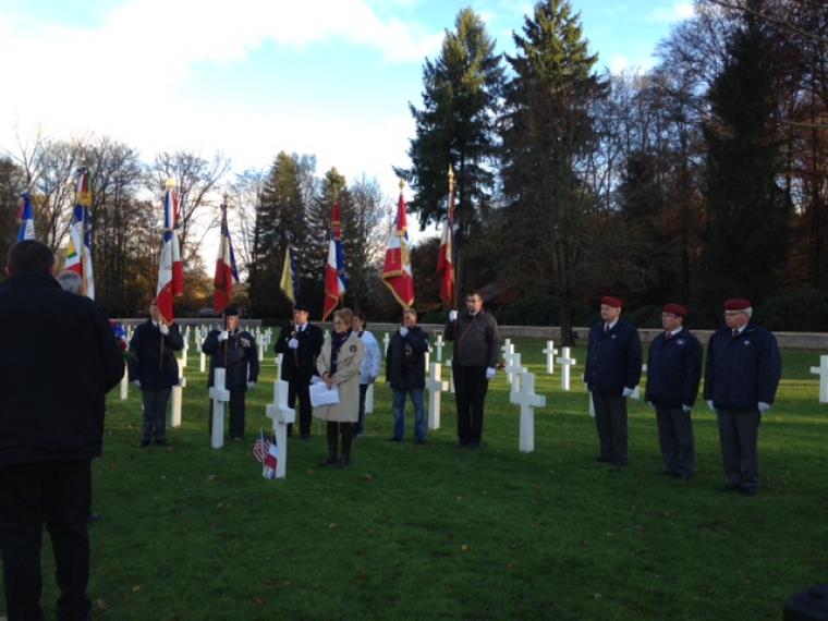 Flag bearers stand behind the one of the adopted graves during the ceremony.